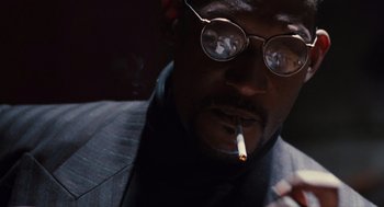Movie still from “The Crow” (1994), directed by Alex Proyas – A person wearing glasses and smoking a cigarette; Close Up shot, Low angle