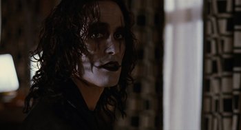 Movie still from “The Crow” (1994), directed by Alex Proyas – A person with long black hair; Close Up shot, Low angle
