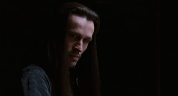 Movie still from “The Crow” (1994), directed by Alex Proyas – A person with long black hair; Close Up shot, Over the shoulder angle