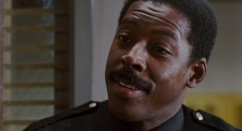 Movie still from “The Crow” (1994), directed by Alex Proyas – A person wearing a police uniform; Close Up shot, Low angle