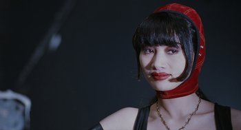 Movie still from “The Crow” (1994), directed by Alex Proyas – A woman wearing a red and black hat and a black dress; Close Up shot, Low angle