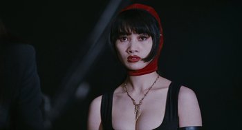 Movie still from “The Crow” (1994), directed by Alex Proyas – A woman wearing a red hood and a black top; Close Up shot, Low angle