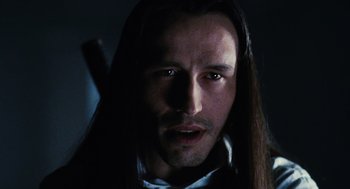 Movie still from “The Crow” (1994), directed by Alex Proyas – A person with long black hair; Close Up shot, Low angle