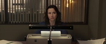Movie still from “The Curse of La Llorona” (2019), directed by Michael Chaves – A woman sitting in front of a printer looking at the camera; Close Up shot, Low angle