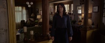 Movie still from “The Curse of La Llorona” (2019), directed by Michael Chaves – A woman standing in front of a mirror in a living room; Medium shot, Over the shoulder angle