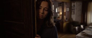 Movie still from “The Curse of La Llorona” (2019), directed by Michael Chaves – A woman standing next to a wooden door in a room; Close Up shot, Over the shoulder angle