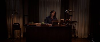 Movie still from “The Curse of La Llorona” (2019), directed by Michael Chaves – A woman sitting at a desk looking at a tablet; Wide shot, High angle