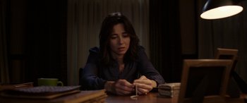 Movie still from “The Curse of La Llorona” (2019), directed by Michael Chaves – A woman sitting at a table with a candle in her hand; Close Up shot, High angle