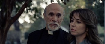 Movie still from “The Curse of La Llorona” (2019), directed by Michael Chaves – An older man and a young woman standing next to each other in front of a tree; Close Up shot, Over the shoulder angle