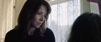 Movie still from “The Curse of La Llorona” (2019), directed by Michael Chaves – A person sitting in front of a window; Close Up shot, Over the shoulder angle