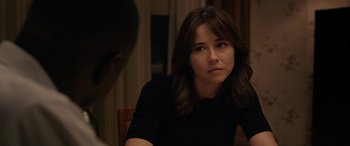 Movie still from “The Curse of La Llorona” (2019), directed by Michael Chaves – A woman sitting in front of a man in front of a wooden table; Close Up shot, Over the shoulder angle