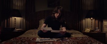 Movie still from “The Curse of La Llorona” (2019), directed by Michael Chaves – A woman sitting on the ground with papers in front of her; Medium shot, High angle