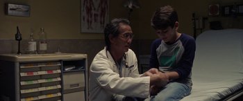Movie still from “The Curse of La Llorona” (2019), directed by Michael Chaves – A man in a white lab coat and a boy in a blue shirt; Medium shot, Over the shoulder angle