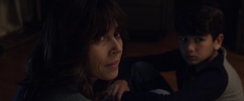 Movie still from “The Curse of La Llorona” (2019), directed by Michael Chaves – A person sitting in the dark; Close Up shot, Over the shoulder angle