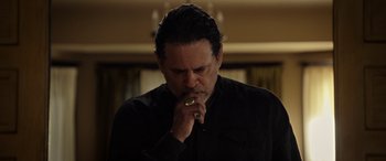 Movie still from “The Curse of La Llorona” (2019), directed by Michael Chaves – A man in a black shirt is smoking a cigarette; Close Up shot, Over the shoulder angle