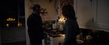 Movie still from “The Curse of La Llorona” (2019), directed by Michael Chaves – A man and a woman standing in front of a stove in a kitchen; Medium shot, Over the shoulder angle