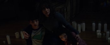 Movie still from “The Curse of La Llorona” (2019), directed by Michael Chaves – A woman and two children in a dark room; Medium shot, High angle