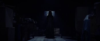Movie still from “The Curse of La Llorona” (2019), directed by Michael Chaves – A woman standing in the dark in front of a brick wall; Wide shot, Low angle