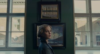Movie still from “The Danish Girl” (2015), directed by Tom Hooper – A woman standing in front of two paintings; Medium shot, Low angle