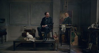 Movie still from “The Danish Girl” (2015), directed by Tom Hooper – A man sitting in front of an easel in a room; Wide shot, Low angle