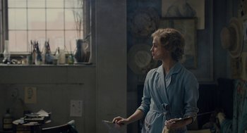 Movie still from “The Danish Girl” (2015), directed by Tom Hooper – A woman in a blue robe holding something in her hand; Medium shot, Over the shoulder angle