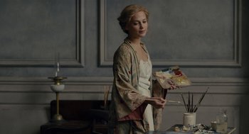 Movie still from “The Danish Girl” (2015), directed by Tom Hooper – A beautiful young woman holding a paint brush and palette; Medium shot, Over the shoulder angle