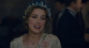 Movie still from “The Danish Girl” (2015), directed by Tom Hooper – A woman wearing a flower crown smiling for the camera; Close Up shot, Over the shoulder angle