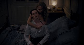 Movie still from “The Danish Girl” (2015), directed by Tom Hooper – A man and a woman sitting on a bed in a room; Medium shot, Overhead angle