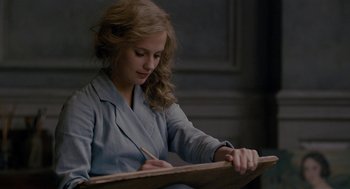 Movie still from “The Danish Girl” (2015), directed by Tom Hooper – A young woman writing on a piece of paper; Close Up shot, Over the shoulder angle