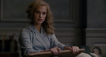 Movie still from “The Danish Girl” (2015), directed by Tom Hooper – A woman sitting in front of a wall holding a board; Close Up shot, Over the shoulder angle
