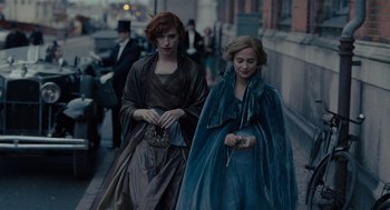 Movie still from “The Danish Girl” (2015), directed by Tom Hooper – Two women walking down a street in a city; Medium shot, Over the shoulder angle