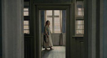 Movie still from “The Danish Girl” (2015), directed by Tom Hooper – A woman standing in a room with a window; Wide shot, High angle