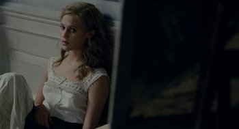 Movie still from “The Danish Girl” (2015), directed by Tom Hooper – A woman sitting in front of a mirror in front of a window; Close Up shot, High angle