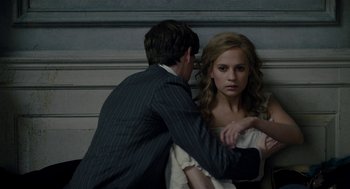 Movie still from “The Danish Girl” (2015), directed by Tom Hooper – A man and a woman standing next to each other in front of a wall; Medium shot, Over the shoulder angle