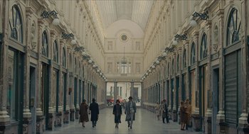 Movie still from “The Danish Girl” (2015), directed by Tom Hooper – A group of people walking down a long hallway; Extreme Wide shot, High angle