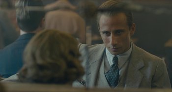 Movie still from “The Danish Girl” (2015), directed by Tom Hooper – A man wearing a suit and tie looking at a mirror; Close Up shot, Over the shoulder angle