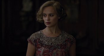 Movie still from “The Danish Girl” (2015), directed by Tom Hooper – A woman in a floral dress looking to her left; Close Up shot, Over the shoulder angle