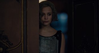 Movie still from “The Danish Girl” (2015), directed by Tom Hooper – A woman standing in front of a door looking sad; Close Up shot, Over the shoulder angle