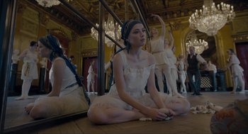 Movie still from “The Danish Girl” (2015), directed by Tom Hooper – A woman sitting on the floor in front of a mirror; Medium shot, High angle