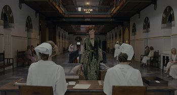 Movie still from “The Danish Girl” (2015), directed by Tom Hooper – A woman in a green dress standing in front of a group of people; Wide shot, Low angle