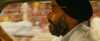 Movie still from “The Darjeeling Limited” (2007), directed by Wes Anderson – A man with a long beard and glasses looking to his left; Close Up shot, Low angle