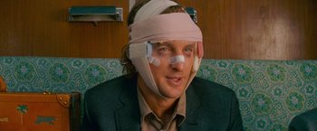 Movie still from “The Darjeeling Limited” (2007), directed by Wes Anderson – A man with a bandage on his head; Close Up shot, Over the shoulder angle