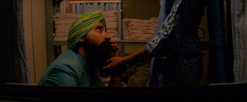 Movie still from “The Darjeeling Limited” (2007), directed by Wes Anderson – A man in a turban is being fitted for a turban; Close Up shot, Over the shoulder angle