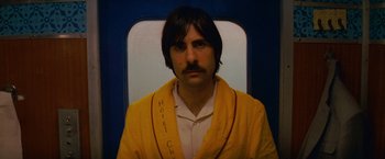 Movie still from “The Darjeeling Limited” (2007), directed by Wes Anderson – A man in a yellow bathrobe on a train; Close Up shot, Low angle