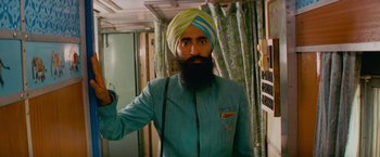 Movie still from “The Darjeeling Limited” (2007), directed by Wes Anderson – A man with a long beard wearing a turban; Medium shot, Low angle