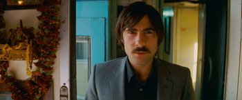 Movie still from “The Darjeeling Limited” (2007), directed by Wes Anderson – A person wearing a suit and tie; Close Up shot, Low angle