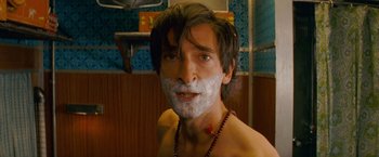 Movie still from “The Darjeeling Limited” (2007), directed by Wes Anderson – A man in a bathroom with a beard on his face; Close Up shot, Low angle