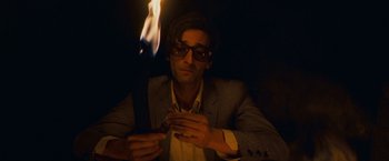 Movie still from “The Darjeeling Limited” (2007), directed by Wes Anderson – A man in a suit and sunglasses holding a cell phone; Close Up shot, Low angle