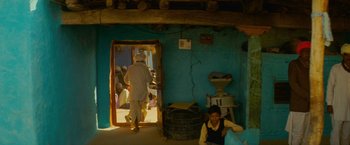 Movie still from “The Darjeeling Limited” (2007), directed by Wes Anderson – A man standing in front of an open door; Wide shot, High angle