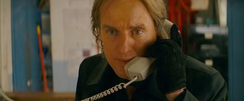 Movie still from “The Darjeeling Limited” (2007), directed by Wes Anderson – A person holding a phone up to their ear; Close Up shot, Low angle